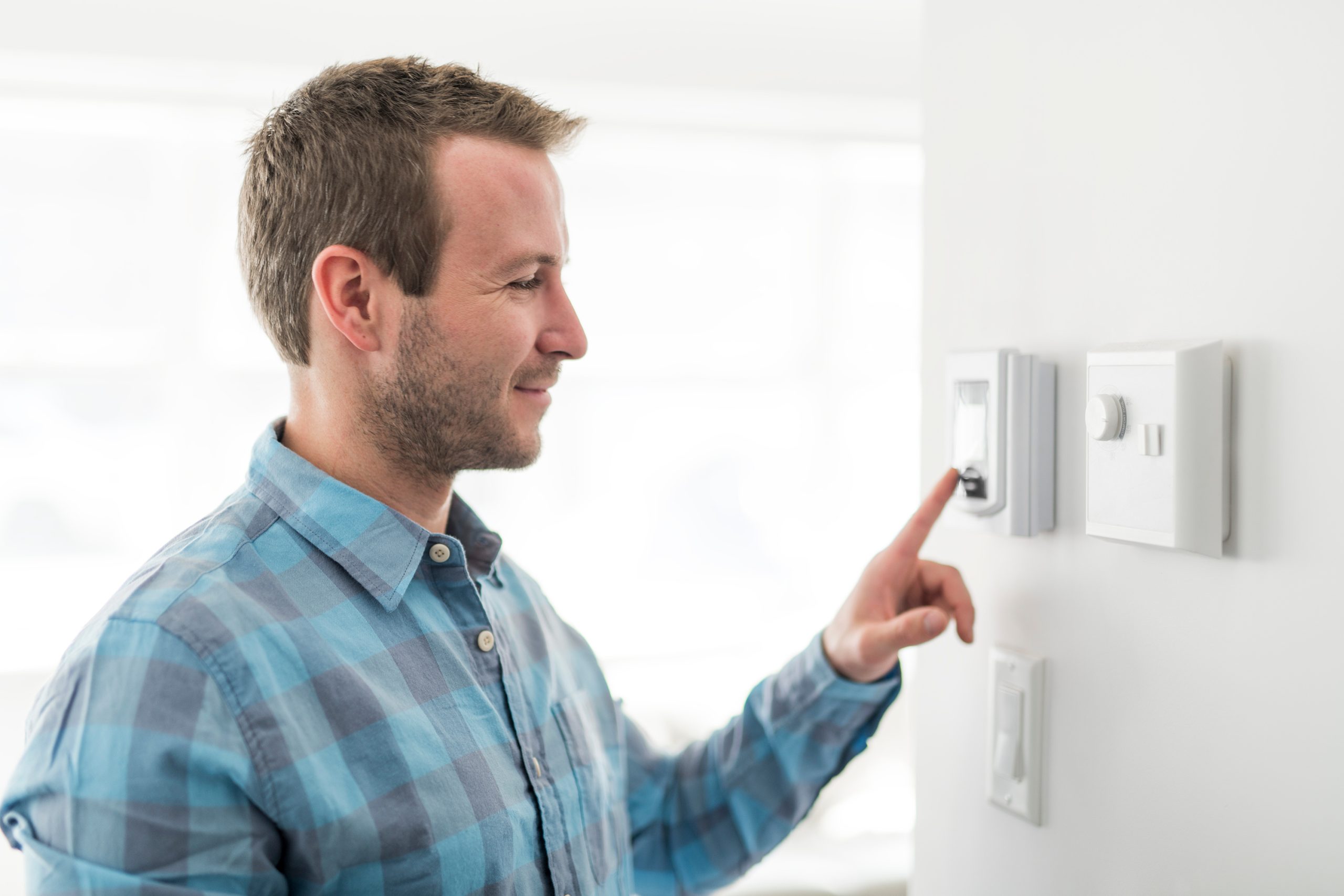 man thermostat set scaled How to Begin Your Net-Zero Journey
